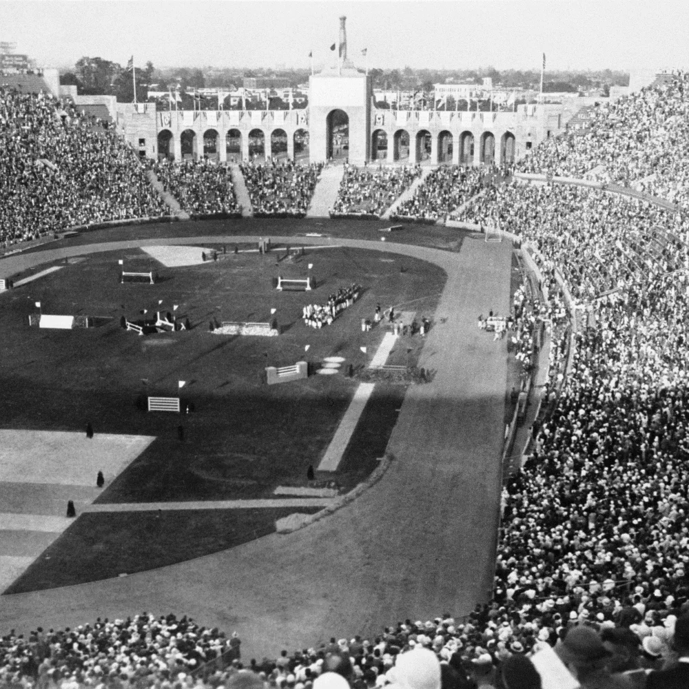 Spectators at the 1932 Games seated at the LA Coliseum watching an event take place on the field.
